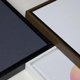 Framed canvas wall art samples with black, brown, and white frames on a light background.