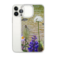 Clear iPhone 13 Pro Max case with wildflower design by a river on white phone